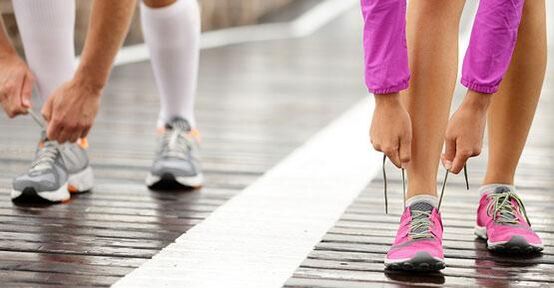 減量のためにジョギングする前に靴紐を結ぶ